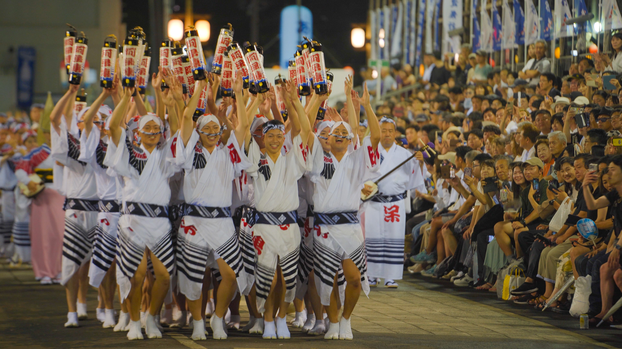 本番の桟敷で、手を挙げて団子の隊形で進む阿呆連の男踊り